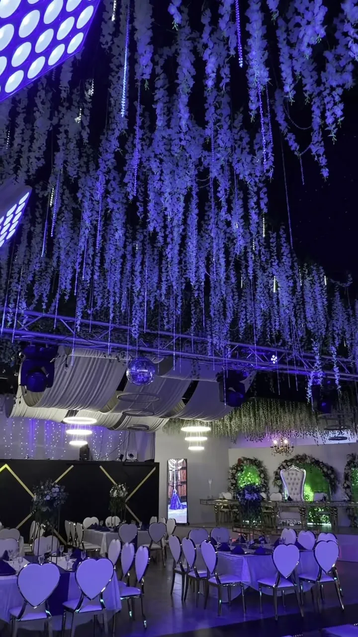 Instalaciones florales blancas en cascada suspendidas del techo sobre la pista.