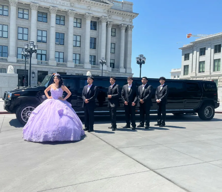 Una quinceañera y su corte junto a la limusina Hummer negra en el Capitolio de Utah.